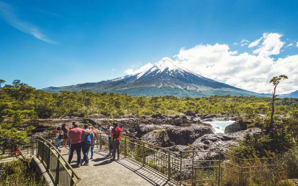 Saltos del Petrohué cascadas sobre roca volcánica negra con volcán Osorno nevado al fondo Patagonia Chile